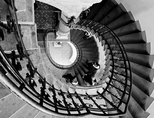 Wrought-iron spiral stair seen from above in a stone well