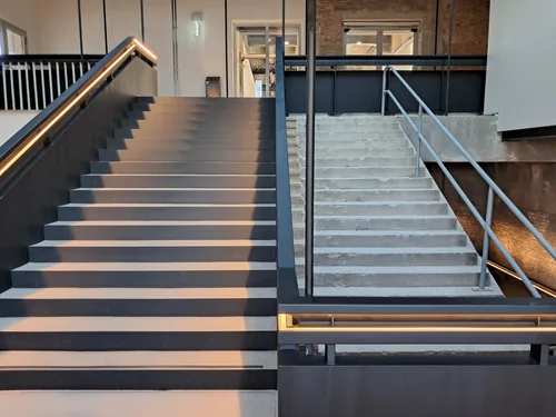 Lit stair with glowing steps rising into a brick hall