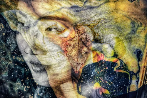 Masquerade by Stephen Spartana. A face half-hidden behind an autumn leaf and a starry dark shape, in yellow, ochre and deep blue.