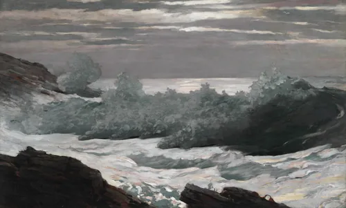 Heavy grey waves break in white foam over dark rocks under a cold, clearing morning sky.