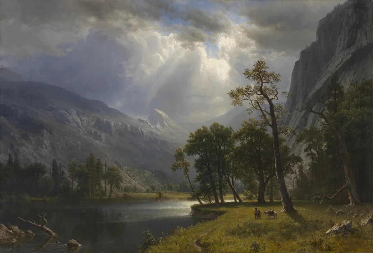 Light breaks through clouds onto a granite valley with a calm river, tall trees and a distant dome-shaped peak.