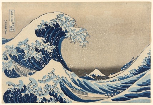 A crashing wave looms over two small ships, Mount Fuji in the background.