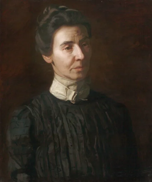 Dark portrait of an older light-skinned women with dark hair in a black dress and white collar, her hair pinned up. Her face is in partial shadow.