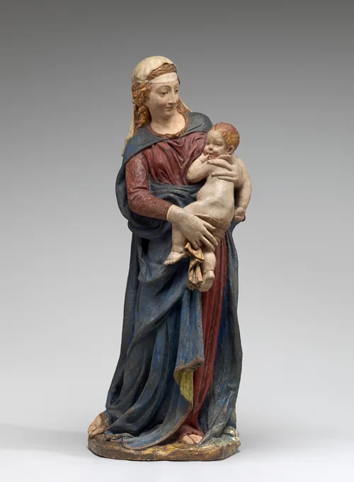 This sculpture depicts a woman holding a small child.