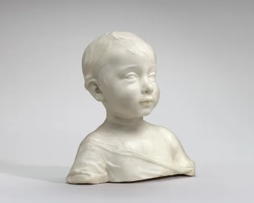 This free-standing, white marble bust shows the head, shoulders, and upper chest of a young boy.