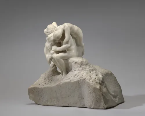 The sculpture depicts three or four intertwined people on a rough base.