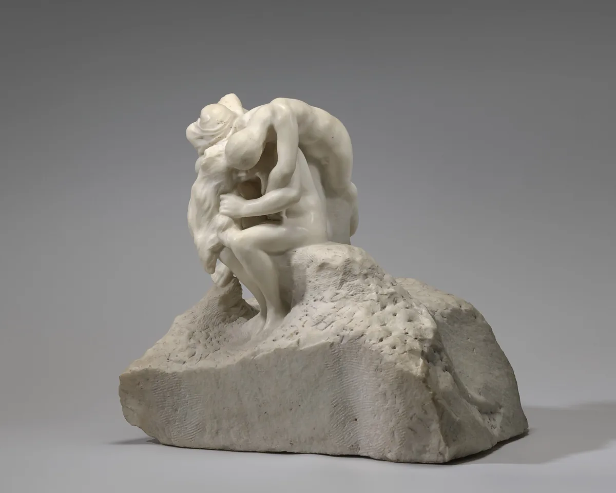 The sculpture depicts three or four intertwined people on a rough base.
