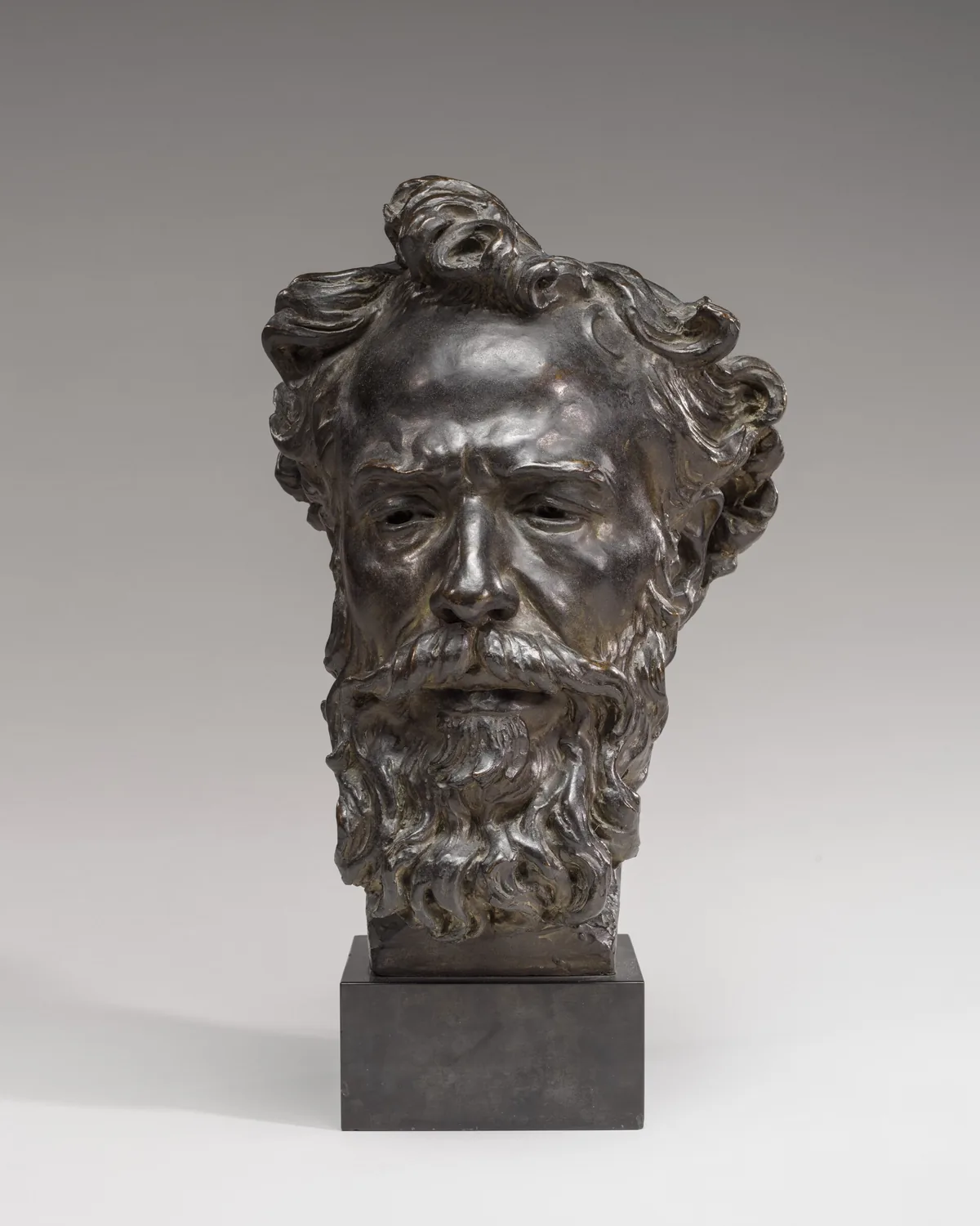 The sculpture shows the head of a man with wavy hair, a full beard, and mustache.