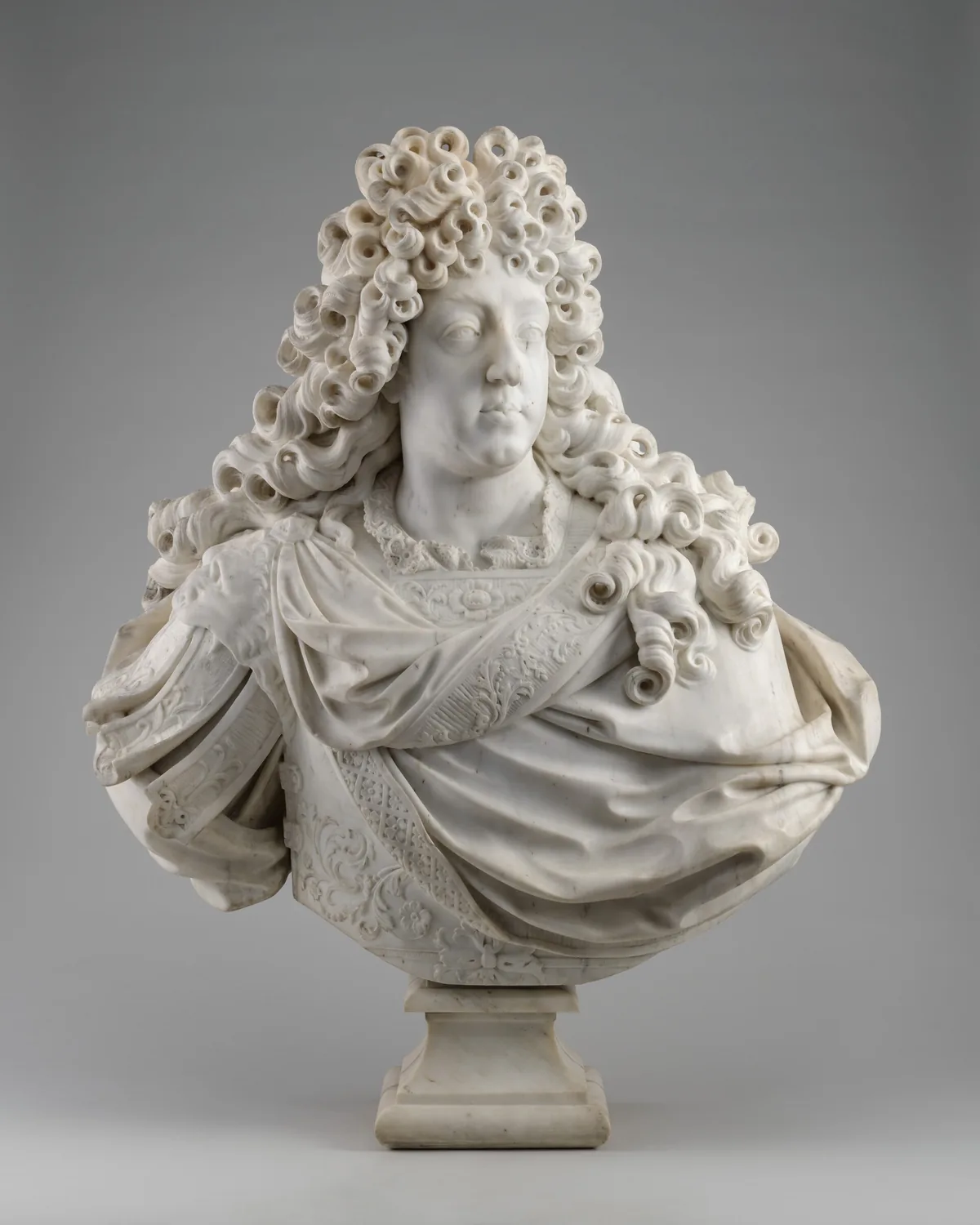 The sculpture is a bust of a man with voluminous curls cascading around his head and shoulders.