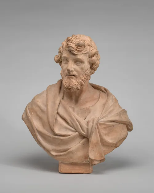 The sculpture is a bust of a bearded man with curly hair, draped in a garment knotted at the front.
