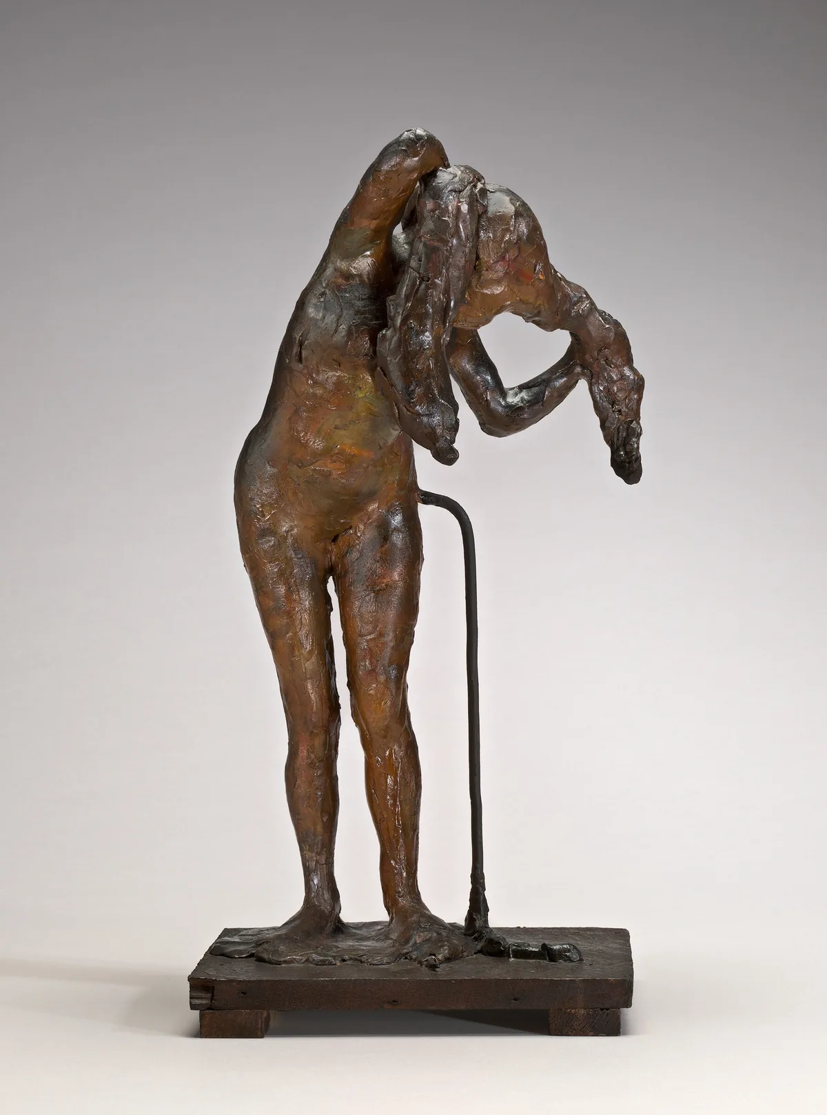 The sculpture depicts a figure of a person in a standing pose with their torso bent forward.