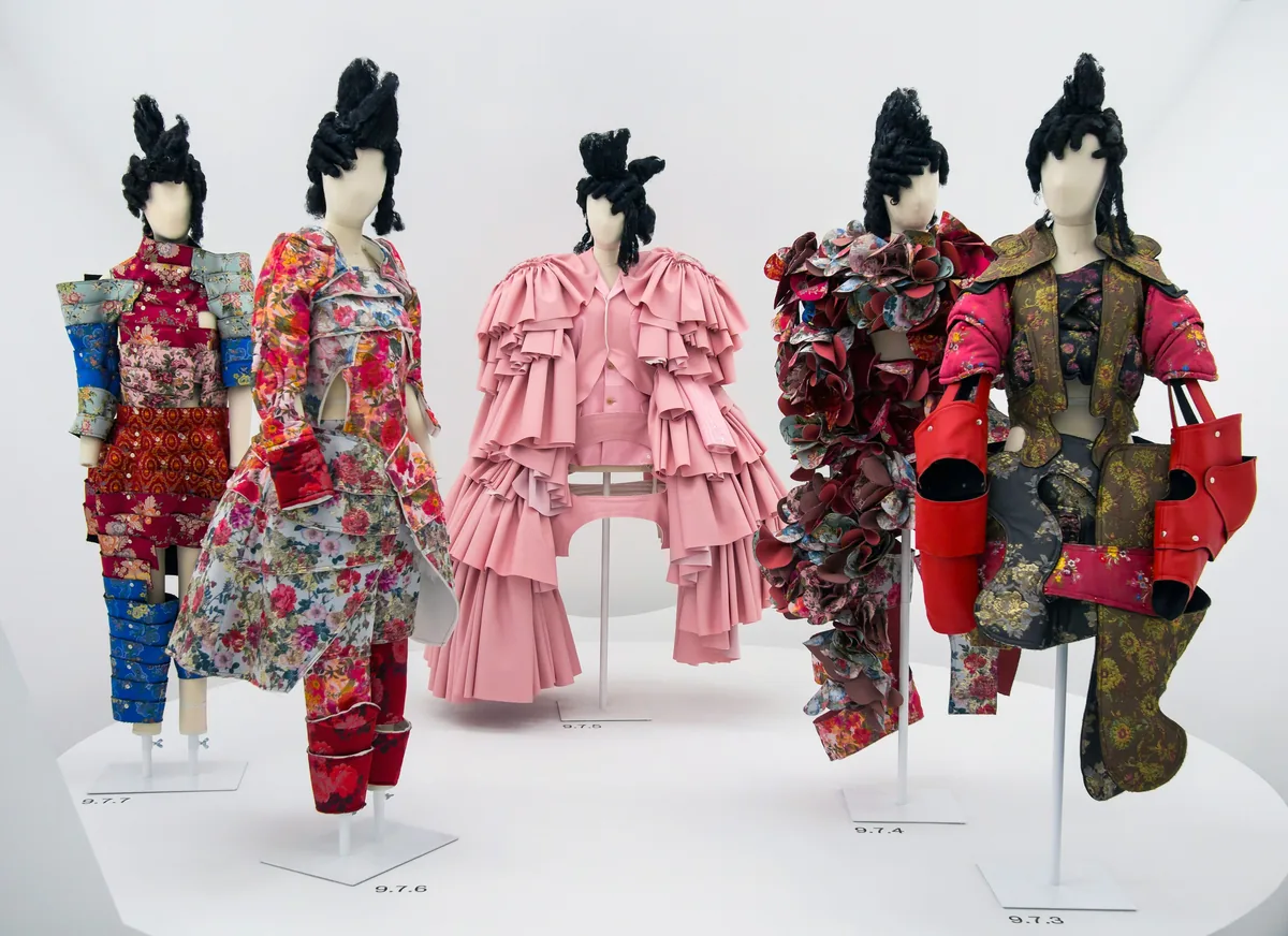 White circular enclosures holding Comme des Garçons garments in the Met’s Costume Institute galleries.