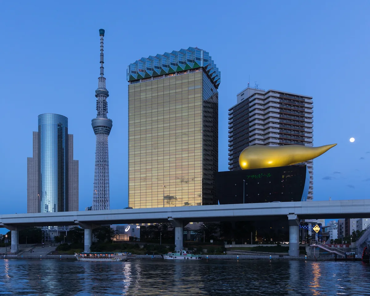 The black Asahi Beer Hall and its golden flame against the Tokyo skyline at blue hour.