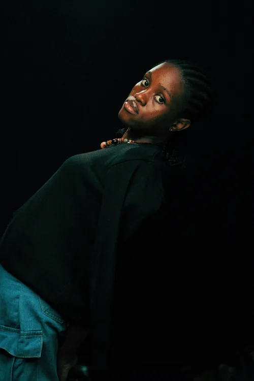 A portrait lit from one side, the sitter turning to look back over a dark shoulder.