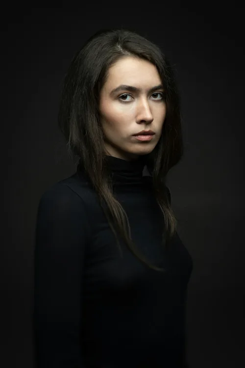 A plain studio portrait, lit for the eyes rather than the clothes.
