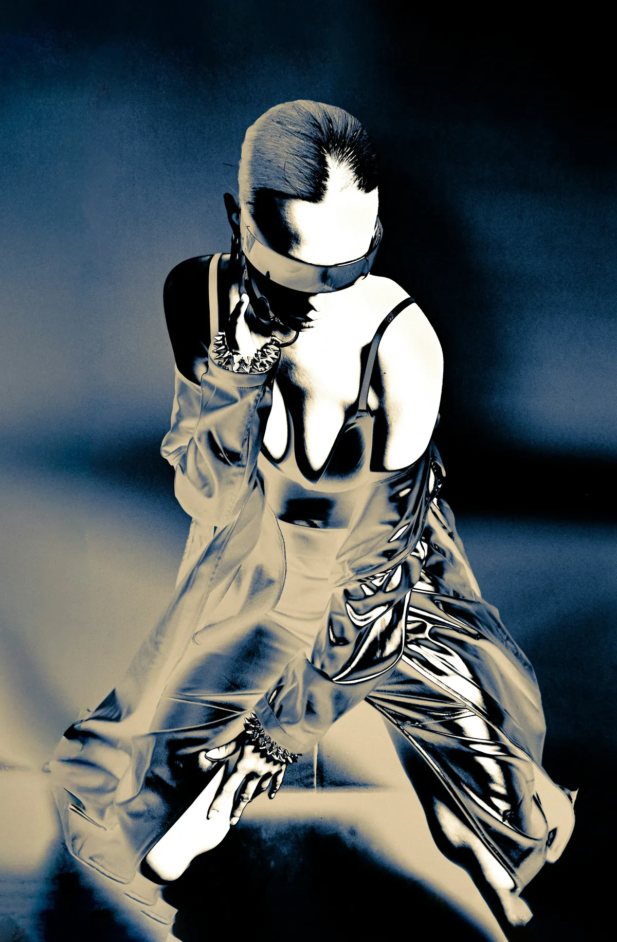 A figure in a metallic, futuristic outfit rendered in stark, near-solarised contrast.