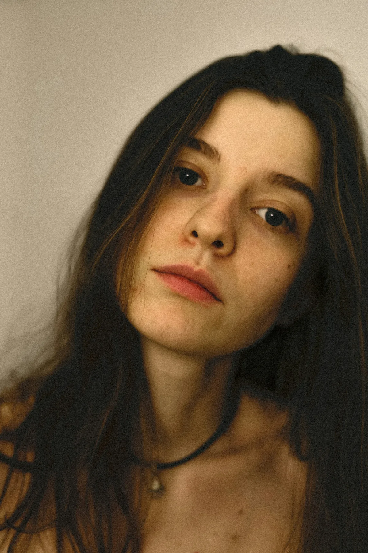 A close, tilted self-portrait in warm natural light, shot on film.